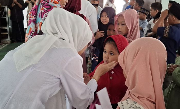 1 Para Wakil Rektor UNISKA turut memberikan santunan dan membelai hangat salah satu peserta, mencerminkan kasih sayang dan kepedulian yang tulus.